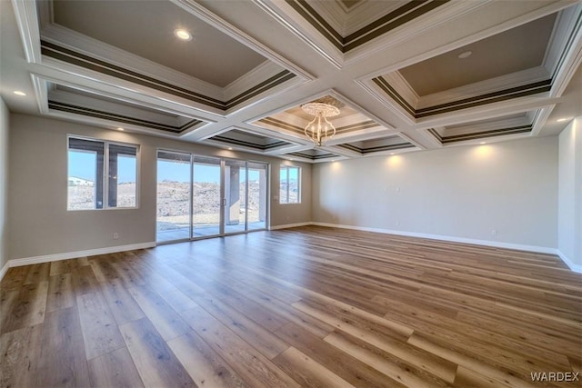 empty room with a healthy amount of sunlight, ornamental molding, and wood finished floors