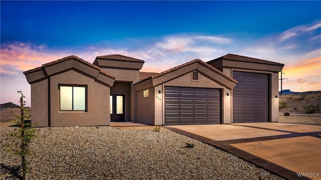 view of front of property featuring a garage, driveway, and stucco siding