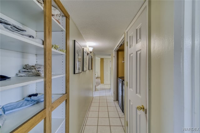 hallway featuring light tile patterned flooring and a textured ceiling