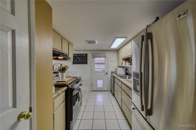 kitchen with visible vents, light countertops, under cabinet range hood, light tile patterned floors, and stainless steel appliances