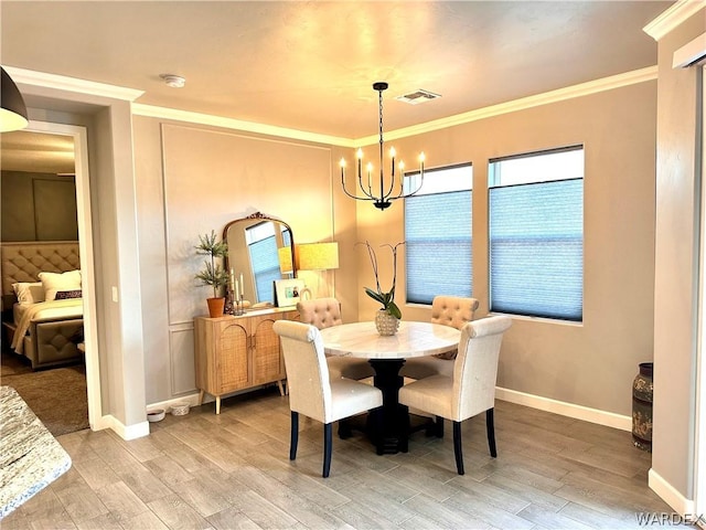 dining space with ornamental molding, wood finished floors, visible vents, and an inviting chandelier