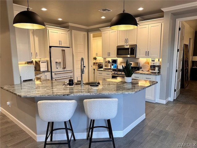 kitchen with visible vents, white cabinets, appliances with stainless steel finishes, dark wood finished floors, and decorative light fixtures