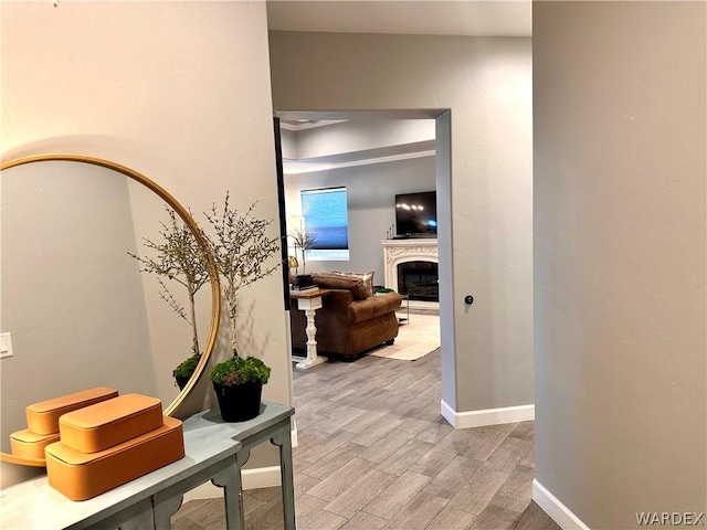 hall featuring light wood-style floors and baseboards