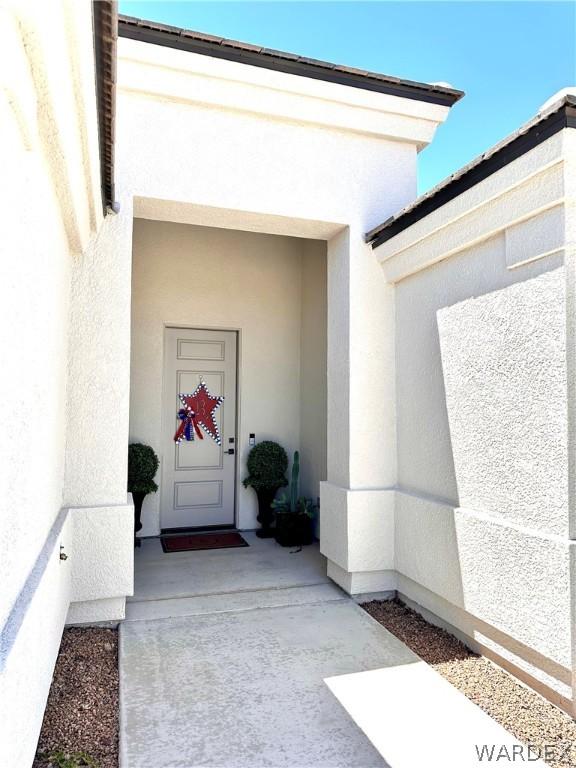 view of exterior entry with stucco siding