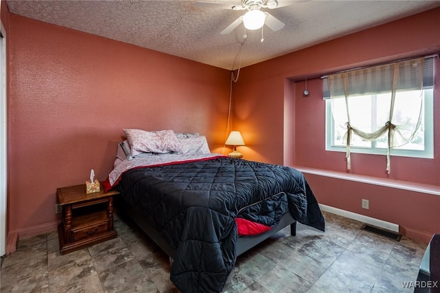 bedroom featuring visible vents, baseboards, a textured ceiling, and ceiling fan