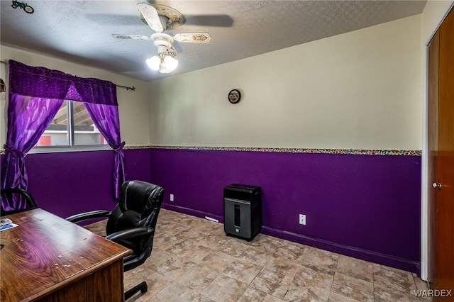 office space featuring baseboards, a textured ceiling, and a ceiling fan