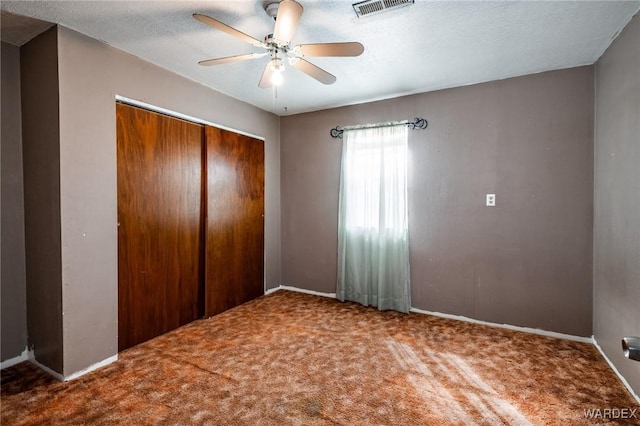 unfurnished bedroom with visible vents, carpet floors, a closet, a textured ceiling, and a ceiling fan