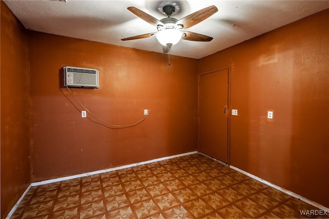 interior space featuring a ceiling fan, light floors, baseboards, and a wall mounted air conditioner