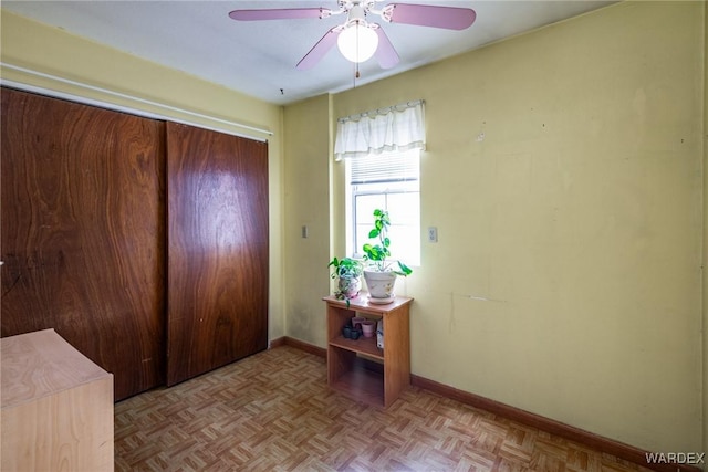 foyer featuring baseboards and a ceiling fan