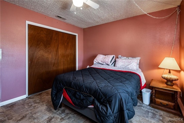 bedroom with visible vents, a ceiling fan, a textured ceiling, a closet, and baseboards