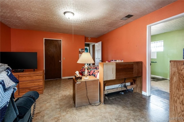 living room featuring baseboards, visible vents, and a textured ceiling