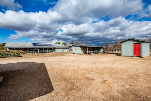 view of yard featuring a shed, an outdoor structure, and fence