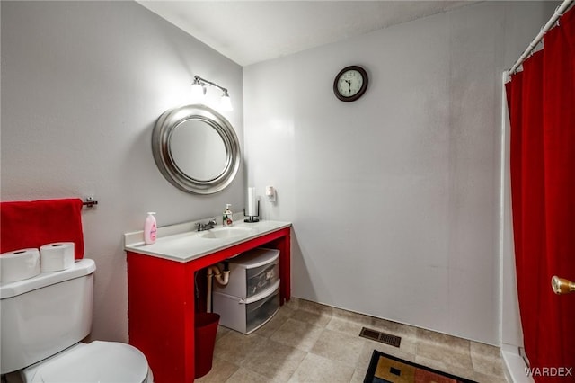 bathroom with vanity, toilet, and visible vents