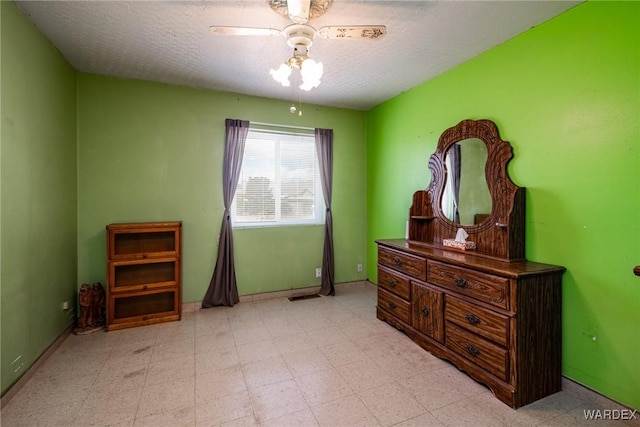 bedroom with tile patterned floors, a textured ceiling, and a ceiling fan