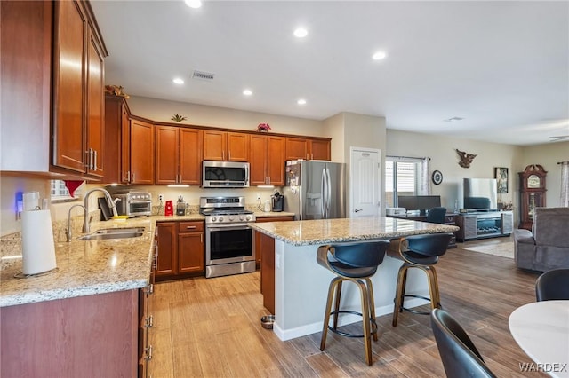 kitchen featuring open floor plan, appliances with stainless steel finishes, visible vents, and light wood-style floors