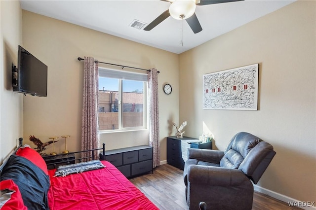 bedroom with baseboards, visible vents, ceiling fan, and wood finished floors