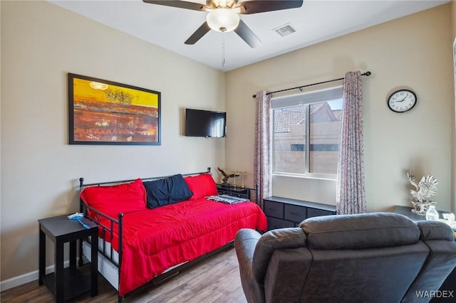 bedroom with visible vents, ceiling fan, baseboards, and wood finished floors