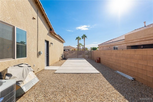 view of yard featuring cooling unit, a fenced backyard, and a patio