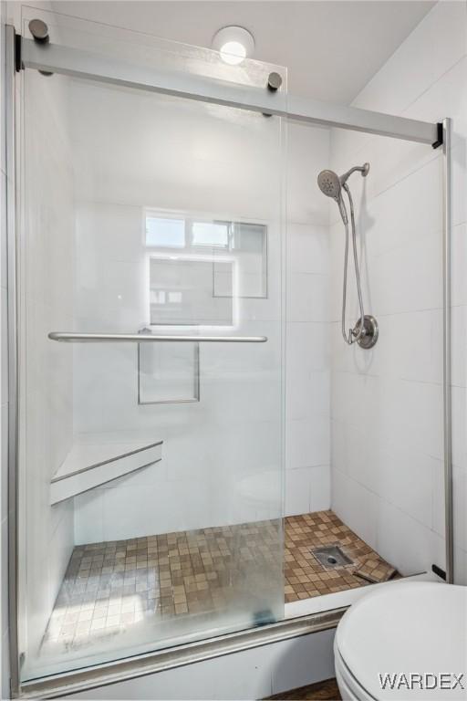 full bath featuring toilet and a shower stall