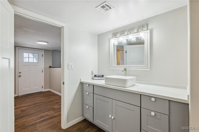 bathroom with vanity, wood finished floors, visible vents, and baseboards