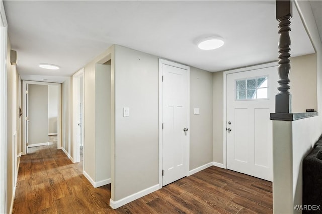 foyer entrance featuring dark wood-type flooring and baseboards