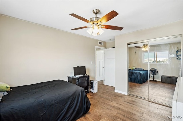 bedroom featuring a closet, visible vents, a ceiling fan, light wood-type flooring, and baseboards