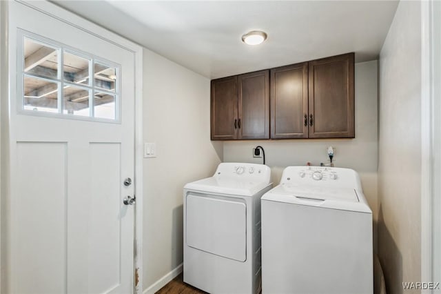 laundry area featuring independent washer and dryer, cabinet space, and baseboards