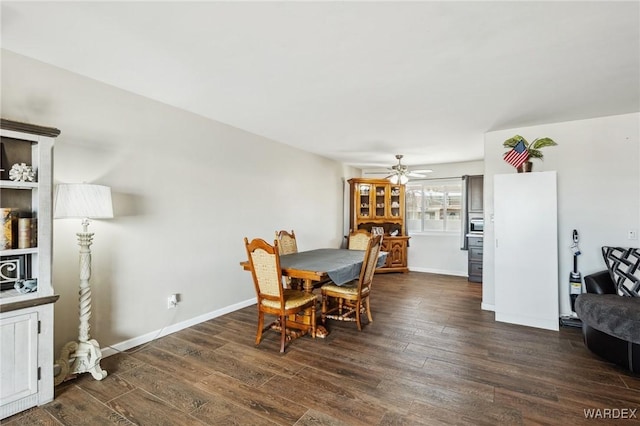 dining room featuring dark wood-style floors, ceiling fan, and baseboards