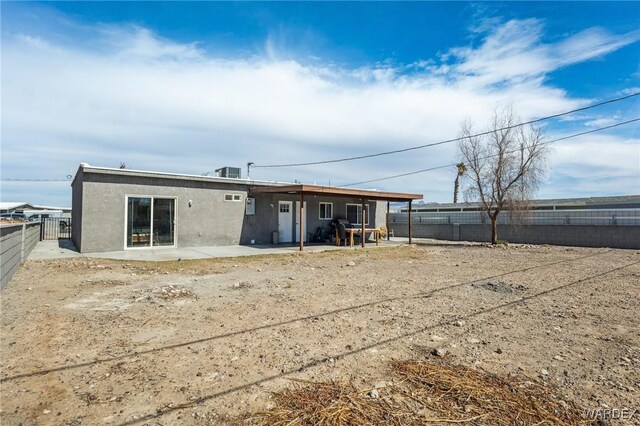 rear view of house featuring a patio area, a fenced backyard, central AC, and stucco siding