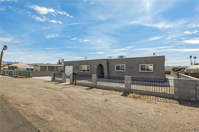 view of front of property featuring a fenced front yard, a gate, and stucco siding