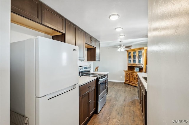 kitchen featuring a ceiling fan, light wood-style floors, light countertops, freestanding refrigerator, and stainless steel range with electric stovetop