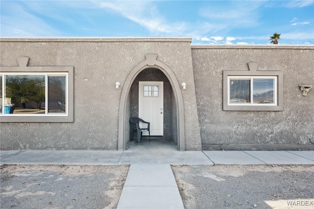 view of exterior entry featuring stucco siding