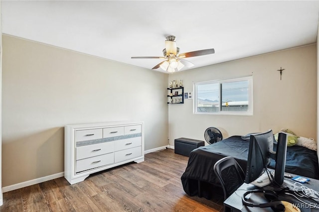 bedroom with ceiling fan, baseboards, and wood finished floors