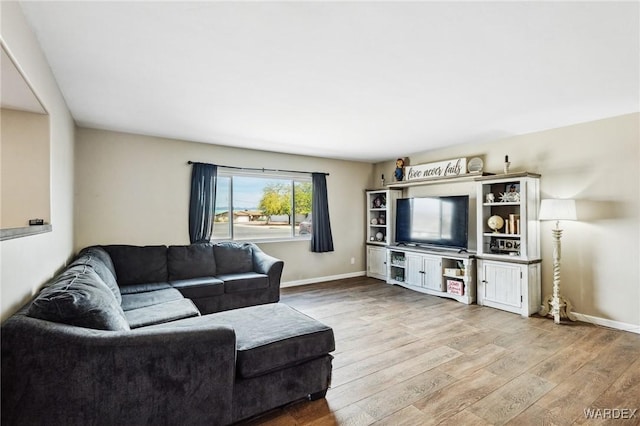 living area with light wood-type flooring and baseboards