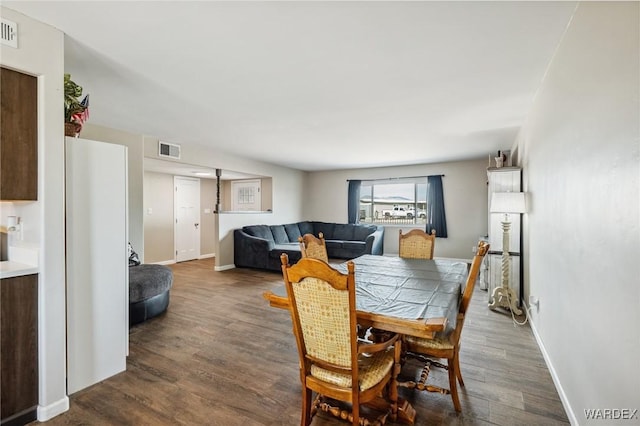 dining space with baseboards, visible vents, and wood finished floors