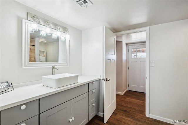 bathroom with baseboards, visible vents, wood finished floors, and vanity