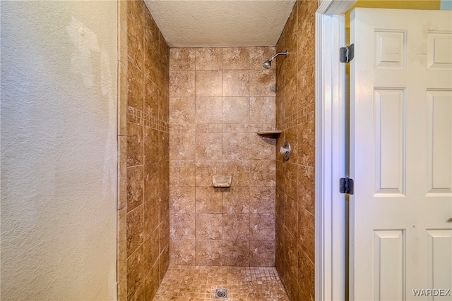 bathroom featuring a textured ceiling, a textured wall, and a shower stall