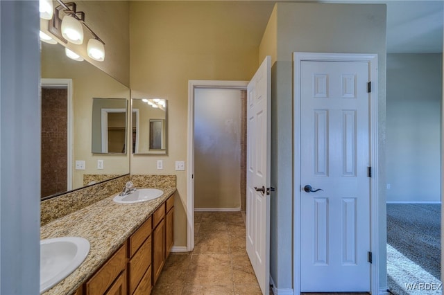 full bath featuring tile patterned flooring, a sink, baseboards, and double vanity