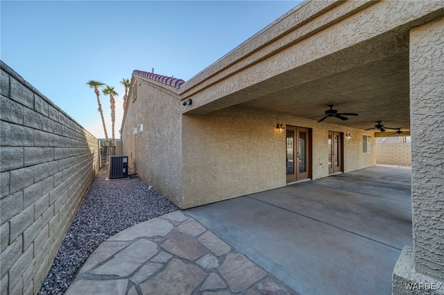 view of patio / terrace with ceiling fan, french doors, cooling unit, and fence