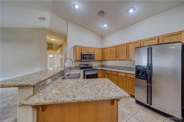 kitchen with visible vents, appliances with stainless steel finishes, a peninsula, a kitchen bar, and a sink