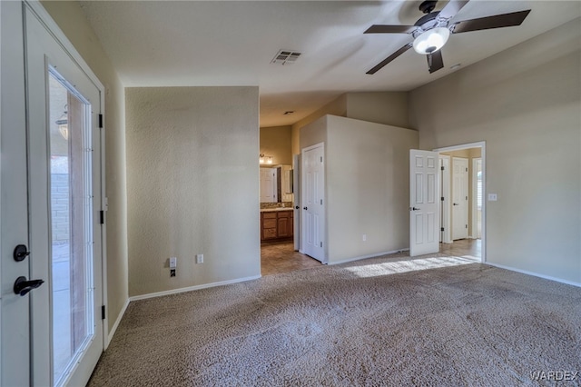 unfurnished bedroom with light carpet, vaulted ceiling, visible vents, and baseboards