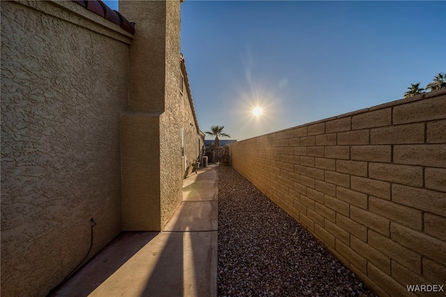 view of home's exterior with fence and stucco siding