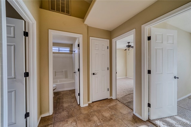 hallway featuring visible vents and baseboards