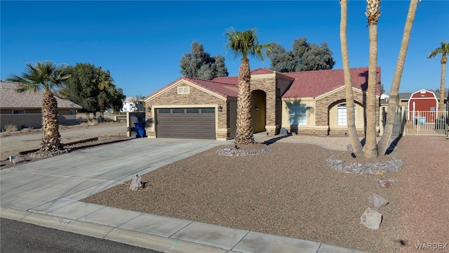 view of front of house with a garage, driveway, stone siding, a tile roof, and fence