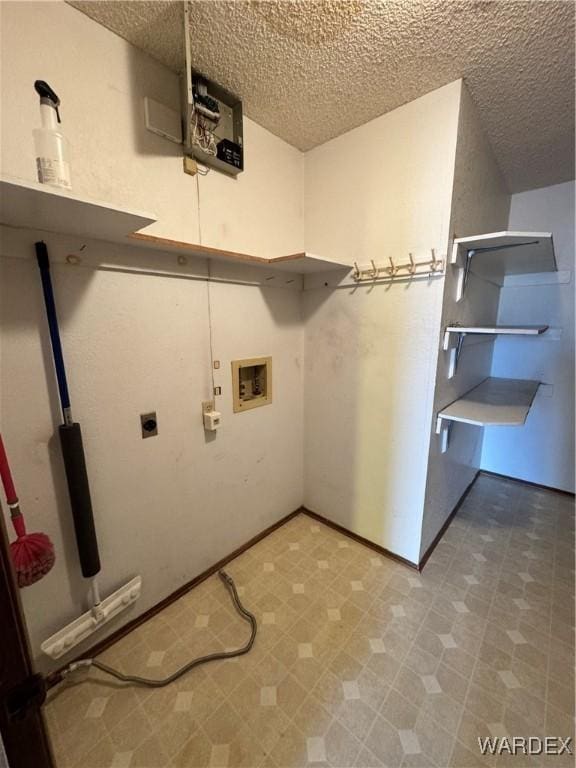 laundry area featuring washer hookup, hookup for an electric dryer, a textured ceiling, laundry area, and tile patterned floors