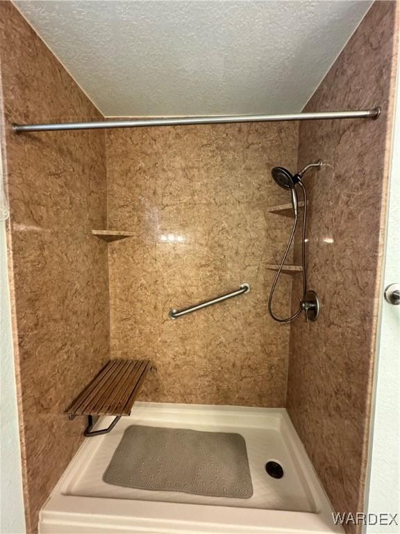 bathroom featuring tiled shower and a textured ceiling