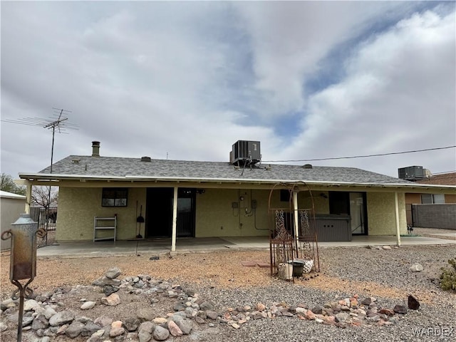 rear view of property with stucco siding, fence, cooling unit, and a patio