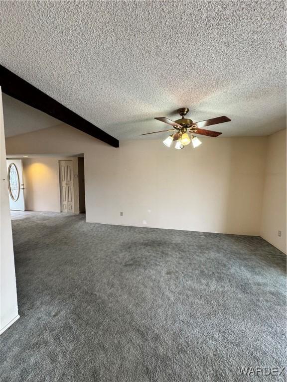 empty room with a ceiling fan, beam ceiling, carpet floors, and a textured ceiling