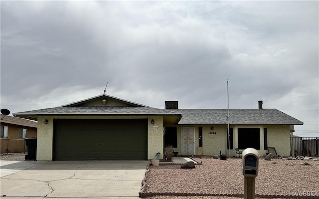 ranch-style home featuring a garage, fence, driveway, roof with shingles, and stucco siding