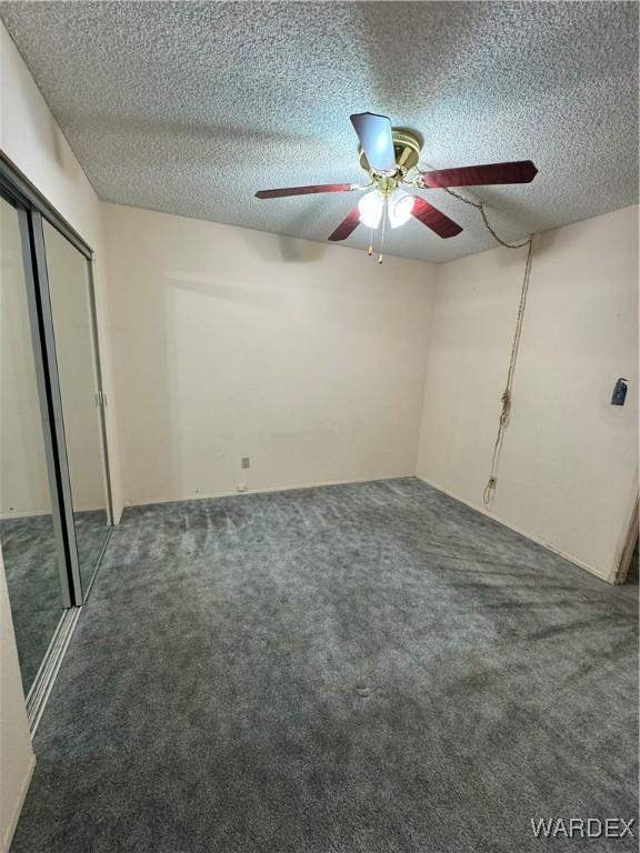 unfurnished bedroom featuring carpet, a closet, a ceiling fan, and a textured ceiling